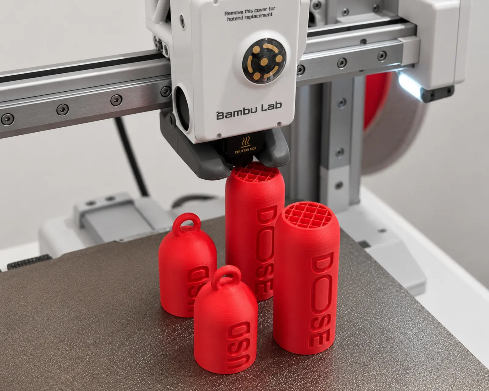 Stampante 3D Bambu Lab al lavoro su contenitori rossi DOSE